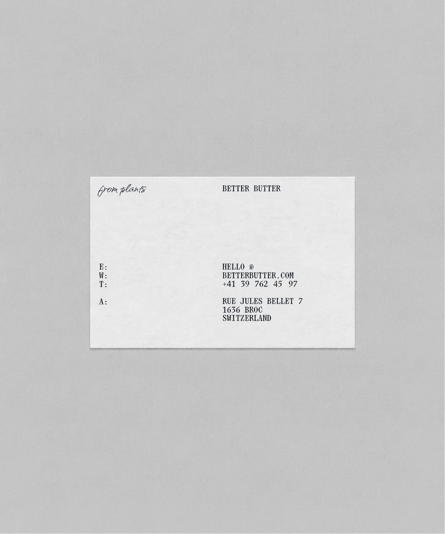 Minimal white printed card with small typographic details on a grey background.