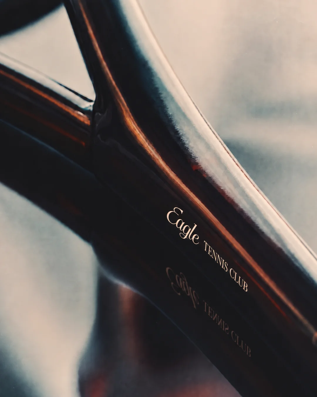 Eagle branding printed on a close-up of a tennis racket frame.